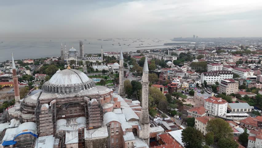 4K drone video orbiting the Hagia Sophia in Istanbul, Turkey with the Blue Mosque visible in the background. Iconic skyline and historic landmarks.