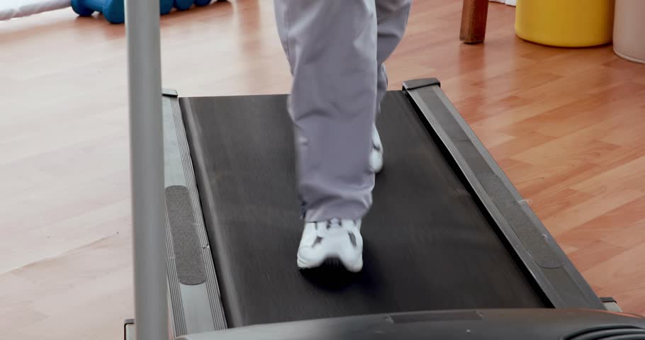 Runner's legs stepping onto treadmill starting belt then enduring brief glitch then maintaining jog. Fitness, endurance, technology, motion, workout, modern, active