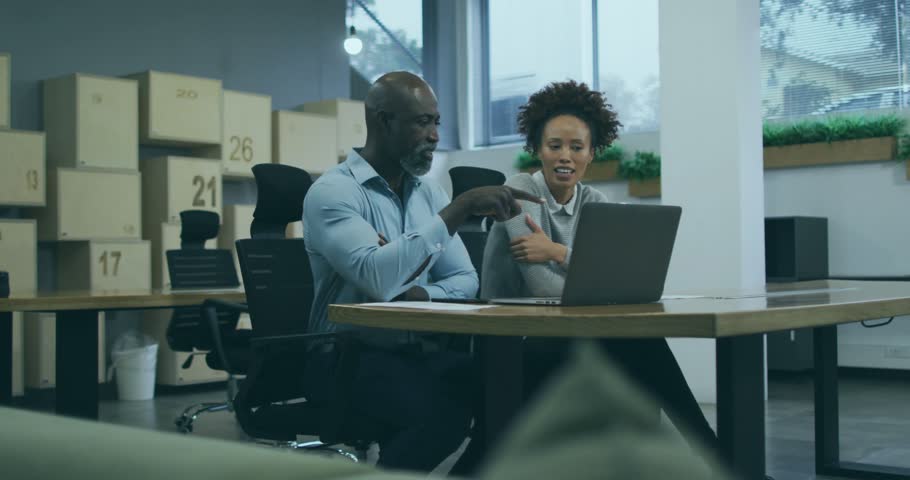 Coworkers pointing at laptop on desk and initiating code overlay for technology debugging session. Collaboration, teamwork, mentorship, programming, officework, modern, professional