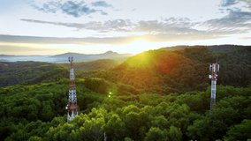 Drone view of forested hills at sunrise with telecom towers transmitting vibrant neon signal trails, illustrating futuristic wireless data communication - Powered by Shutterstock - Get 15% off with code: PIKWIZARD15