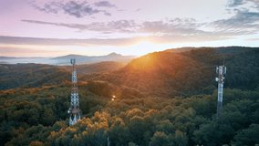 Sweeping aerial shot of telecom towers beaming colorful neon data signals through lush forest at dusk depicting advanced connectivity and modern wireless infrastructure in scenic mountain environment - Powered by Shutterstock - Get 15% off with code: PIKWIZARD15