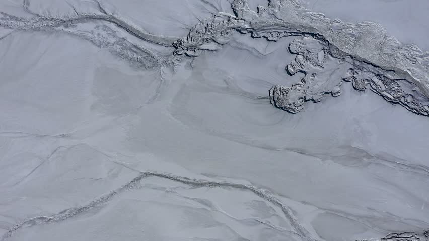 Aerial view of gray abstract mud patterns and cracks on acid mine drainage surface