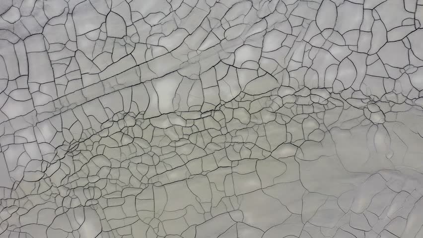 Aerial view of gray abstract mud patterns and cracks on acid mine drainage surface