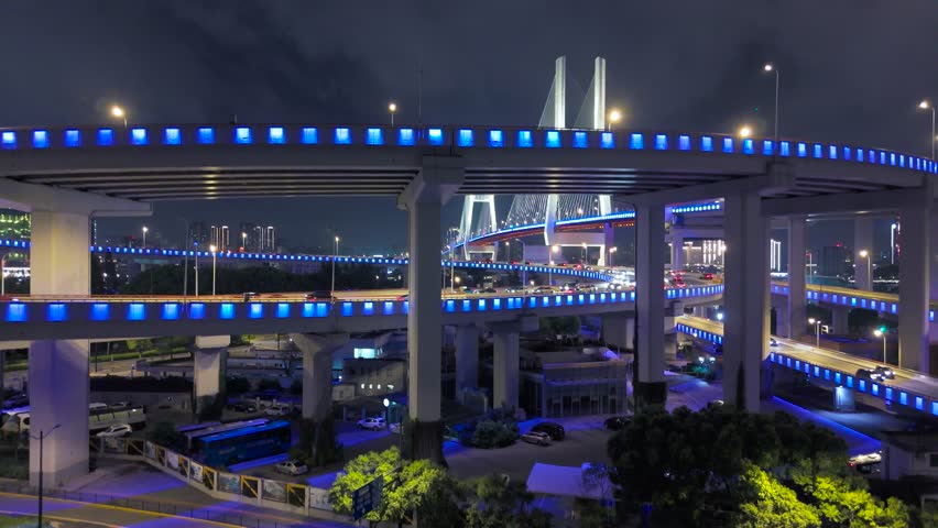 Aerial illuminated elevated highways and the Nanpu Bridge at night with busy traffic in Shanghai, China.