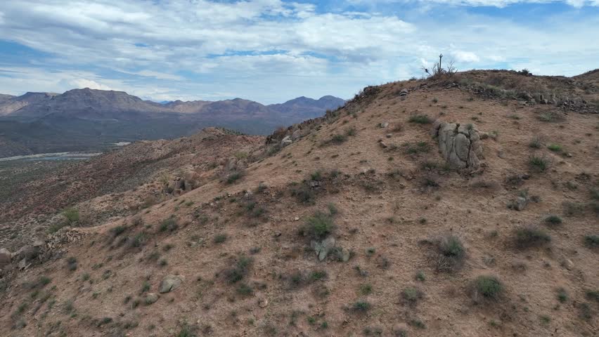 Aerial view of Bartlett Lake surrounded by rugged terrain and sparse vegetation under a partly cloudy sky, Bartlett Lake, Arizona, United States.