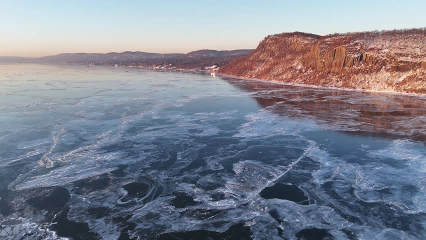 Aerial view of the Hudson River with ice formations creating a mesmerizing pattern, contrasting with the snow-covered cliffs, Hudson River, United States.
