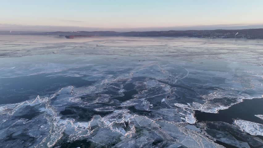 Aerial view of icy landscape, with large ice floes scattered across the Hudson River, creating a mosaic of white and blue textures, Hudson River, United States.