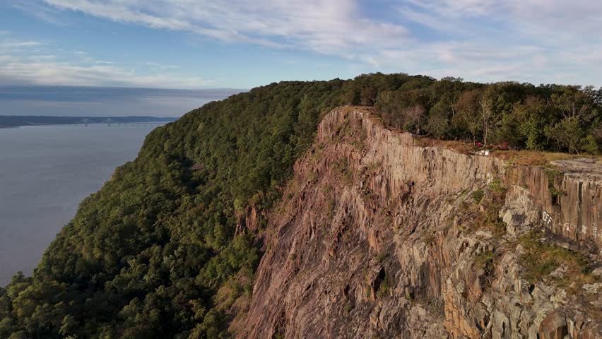 Aerial view of the majestic cliffs and lush forest bordering the tranquil Hudson River, creating a stunning contrast of natural beauty, Hudson River, United States.