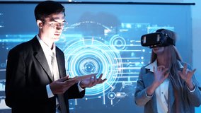 female IT developer stands wearing VR glasses explaining to a male staff member in a suit how to use a data management system for data statistics, data analysis and behind a slide on a conference room - Powered by Shutterstock - Get 15% off with code: PIKWIZARD15