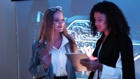 Two female IT developers stand explaining how to use a data management system, business intelligence, data statistics, marketing analysis, and behind a slide on a conference room screen. - Powered by Shutterstock - Get 15% off with code: PIKWIZARD15