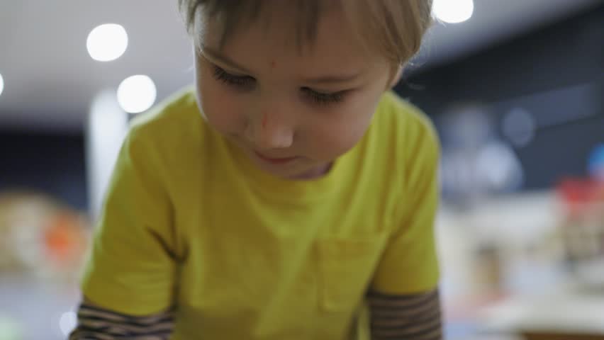 Curious little boy playing and learning in a museum
