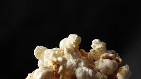 Slow motion close-up of fresh popcorn kernels popping and bouncing on a black background. Premium snack footage ideal for cinema marketing, food advertising, and entertainment content. - Powered by Shutterstock - Get 15% off with code: PIKWIZARD15