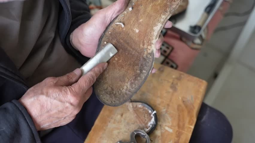 Old shoe master renews the soles of old shoes
