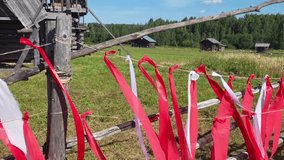 Wooden fence decorated with red and white ribbons during folk festival. Traditional holiday decoration outdoors. - Powered by Shutterstock - Get 15% off with code: PIKWIZARD15