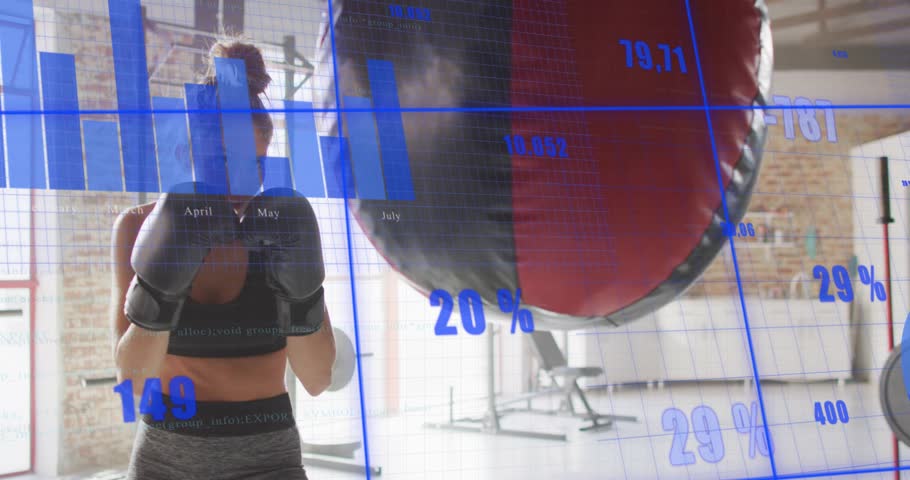 Woman entering boxing stance at heavy bag activating metrics, delivering jabs to track fitness data. Athletic, strength, technology, fitness, training, determination, performance