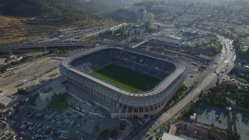 The western facade of Teddy Stadium Jerusalem, israel is bathed in golden light as the drone sweeps left in a gentle low parallax motion
