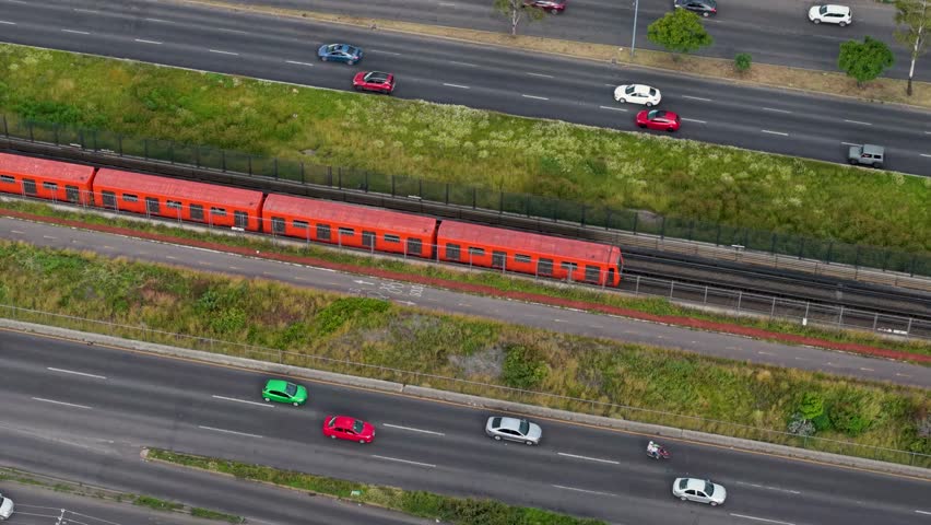 Drone footage of orange Mexico City Metro train on Ecatepec Avenue