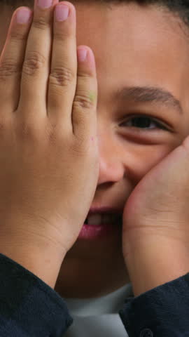 Little boy African American ethnic kid close face with hands palms happy laughing child son boy playing peek a boo game peek-a-boo play hide and seek joyful smiling at home laugh fun fooling around