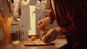 A man peels a pumpkin in a warm, cozy kitchen. Preparing ingredients for a delicious homemade dish. The process of preparing pumpkin for making creamy soup in the fall - Powered by Shutterstock - Get 15% off with code: PIKWIZARD15
