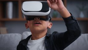 Little African American boy son play VR game kid child in virtual reality at home AR technology playing innovative futuristic gaming cyberspace internet online funny using metaverse enjoy interface - Powered by Shutterstock - Get 15% off with code: PIKWIZARD15