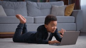 African American kid boy typing laptop at home happy talking smiling school pupil studying online distant education playing game internet gaming watching class video call e-learning little child son - Powered by Shutterstock - Get 15% off with code: PIKWIZARD15
