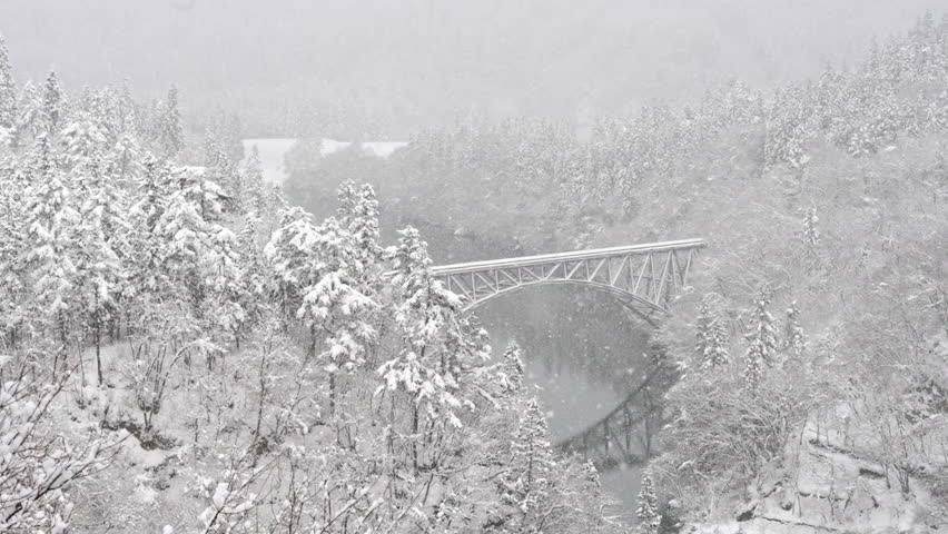 High angle view Landscape of Railway bridge between forest mountain over the river in snow day. Beautiful scenic nature pine tree forest covered in snow in winter season.