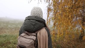 Autumn hiking. Woman with backpack walking through birch forest in fog. Slow motion handheld shot - Powered by Shutterstock - Get 15% off with code: PIKWIZARD15