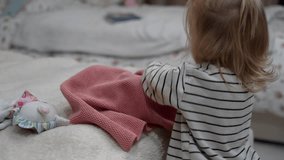 Toddler's hand gently explores soft textiles on cozy, unmade bed, creating serene scene of innocent discovery and domestic comfort. - Powered by Shutterstock - Get 15% off with code: PIKWIZARD15