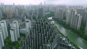 Aerial view of a distinctive terraced residential building with abundant greenery, surrounded by numerous high-rise apartment blocks and a winding river, Shanghai. - Powered by Shutterstock - Get 15% off with code: PIKWIZARD15