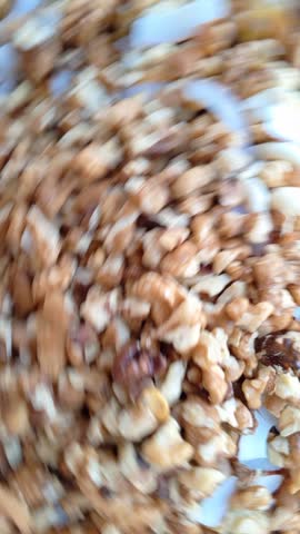 Close-up video of mixed nuts and coconut slices — chopped walnuts, cashews, and fresh coconut. Golden-brown textures and creamy white coconut evoke healthy snacking, baking, and gourmet trail mix.

