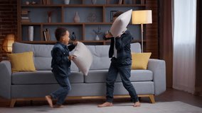 Two playful little African American kids fighting with pillows at home boys siblings brothers sons friends children enjoy fun playing funny fight battle game bit with cushions happiness family play - Powered by Shutterstock - Get 15% off with code: PIKWIZARD15