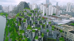 Aerial of the '1000 Trees' building, a terraced architecture with green trees and vegetation, situated by a river in Shanghai, China. - Powered by Shutterstock - Get 15% off with code: PIKWIZARD15