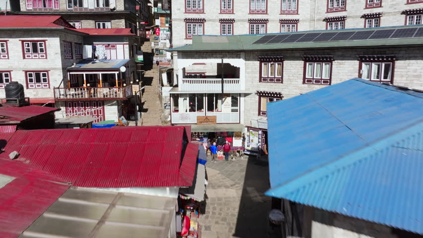 Aerial view of stone buildings in a Nepali village, highlighting traditional architecture and modern solar panels