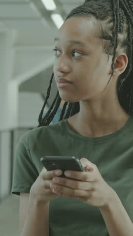 Female High School Student Looking at Smart phone at Break in University