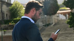 Man in stylish suit using smartphone near urban architecture. Scene reflects business communication, stock market updates, social media chatting online dating. Modern lifestyle of professional male - Powered by Shutterstock - Get 15% off with code: PIKWIZARD15