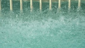 Close-up of turquoise water splashing intensely, likely at the bottom of a water slide, with vertical safety bars visible in the background.
 - Powered by Shutterstock - Get 15% off with code: PIKWIZARD15