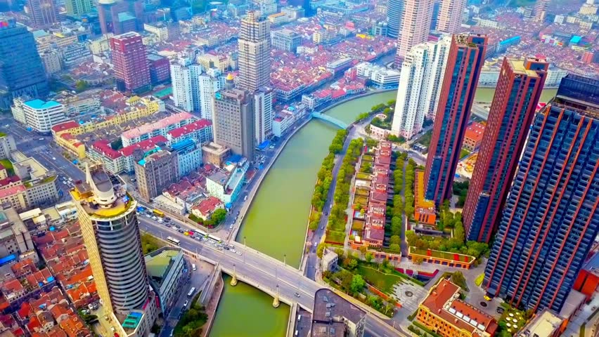 A high-angle aerial shot captures a scenic urban waterway running through a dense area of Shanghai, China. Shanghai, China, 3 August 2025.