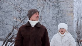 Cheerful mature woman playfully jumping on her husband's back for a piggyback ride. Happy senior couple having fun in a snowy park - Powered by Shutterstock - Get 15% off with code: PIKWIZARD15