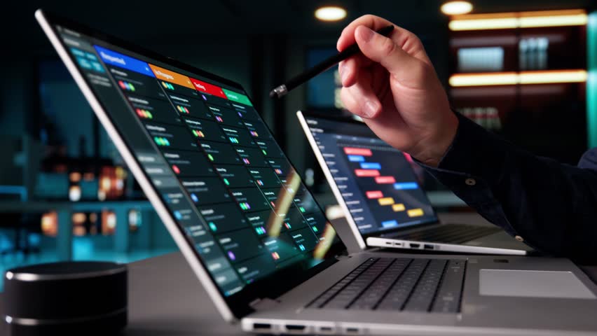 Agile Man Managing Multiple Boards On Laptop Computers