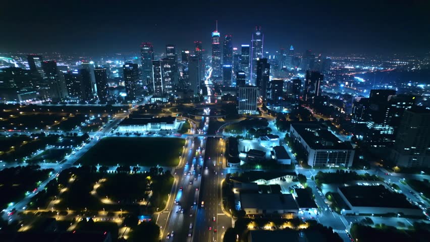 City Skyline at Night, A cinematic aerial drone shot gliding over a glowing modern city skyline at night. Skyscrapers sparkle with lights, and traffic streams form long exposure trails on the 