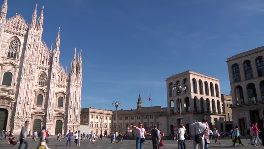 MILAN - CIRCA 2012 - A wide pan over the Piazza del Duomo. Duomo di Milano in the middle is the cathedral church of the city, the fifth largest cathedral in the world and the largest in Italy Royalty-Free Stock Footage #3908108