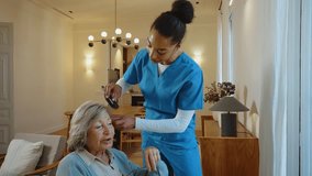 Caring female nurse assists senior woman in wheelchair with getting dressed in a cozy home living room, offering compassionate support, companionship and gentle elderly care - Powered by Shutterstock - Get 15% off with code: PIKWIZARD15