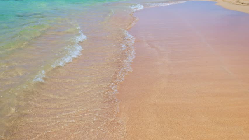 Beautiful view of waves of Atlantic Ocean rolling on sandy beach with clear water in sunlight. Dominican. Punta Cana.