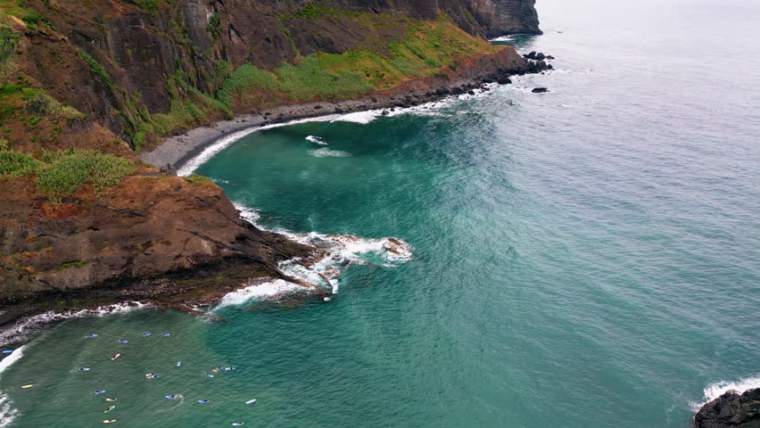 Cliffside formation standing Atlantic ocean water. Beautiful greenery spreading rocky slope. Powerful sea waves crashing stone shoreline splashing with white foam. Blue tide rolling on coastal cliffs. - Powered by Shutterstock - Get 15% off with code: PIKWIZARD15