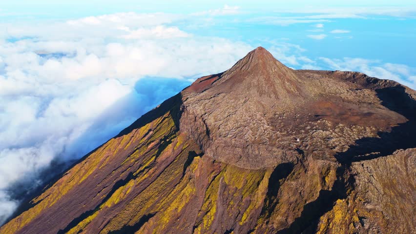 Top of Mount Pico Stratovolcano, Crater and Clouds. Shadow of Mountain. Atlantic Ocean. Pico Island, Azores. Portugal. Aerial View. Orbiting
