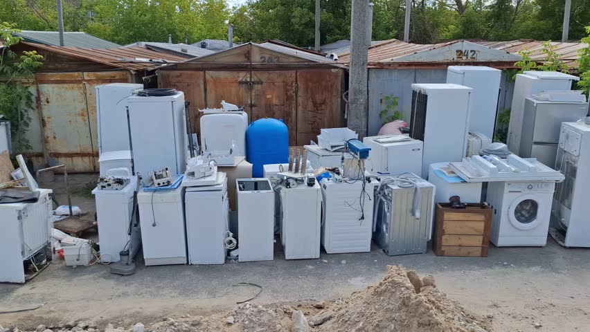 Old washing machines and refrigerators at point of reception of non-working techniques. Old household appliances will be dismantled, sorted by metals and sent for recycling, something will be repaired