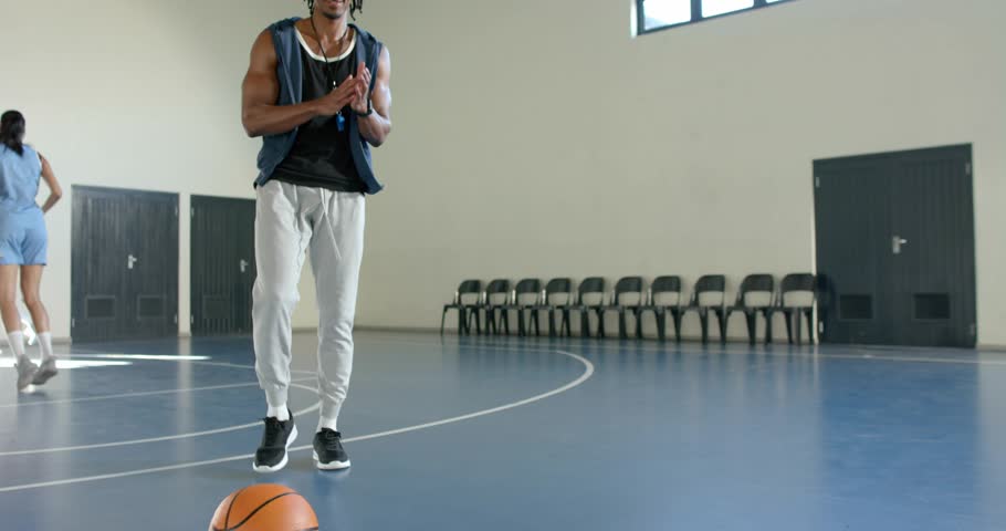 Gym trainer clapping initiating drill, binary overlay streaming and athlete jogging with basketball. Training, fitness, digital, sport, motivation, performance, technology