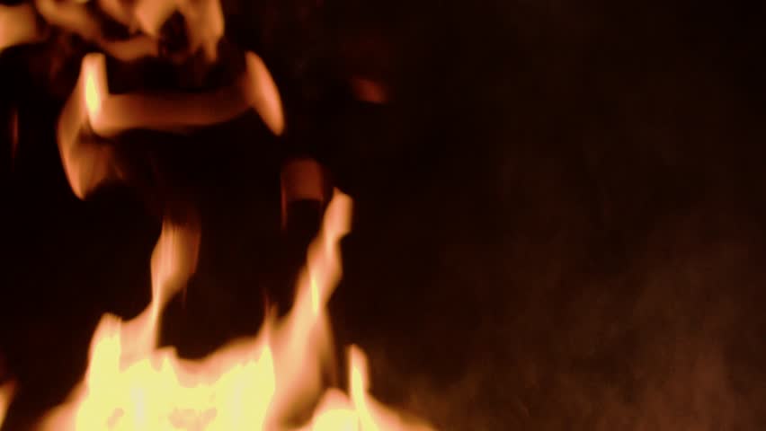 Dynamic close-up shot of slow motion fire flames and glowing sparks rising against a dark background. Ideal for use in cinematic scenes, survival themes, or dramatic visual effects. - Powered by Shutterstock - Get 15% off with code: PIKWIZARD15