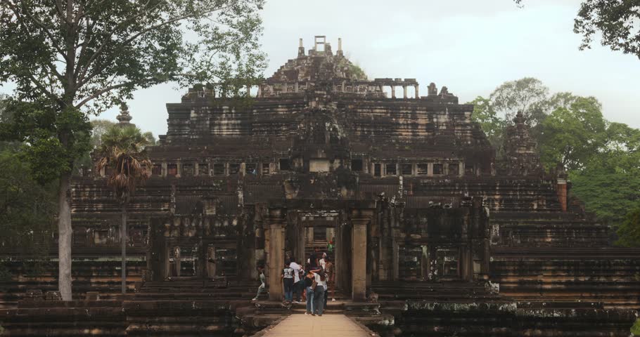 Tourists walk towards the entrance of Baphuon Temple, Angkor Archaeological Park, Cambodia. Perfect conceptual stock footage for travel ads, documentaries, cultural heritage promos, and tourism videos