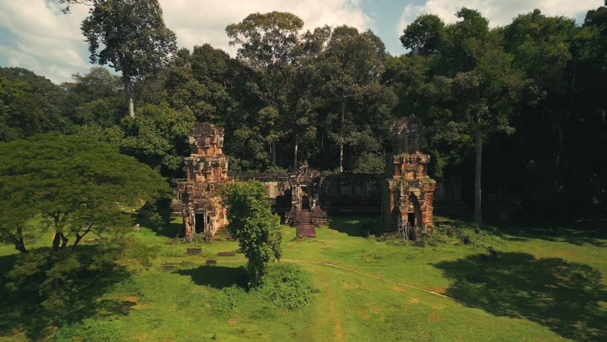 Drone captures Suor Proat Temple in Angkor Thom, Cambodia, surrounded by lush tropical jungle. High quality stock footage for cultural documentaries, tourism campaigns, and travel promos showcasing